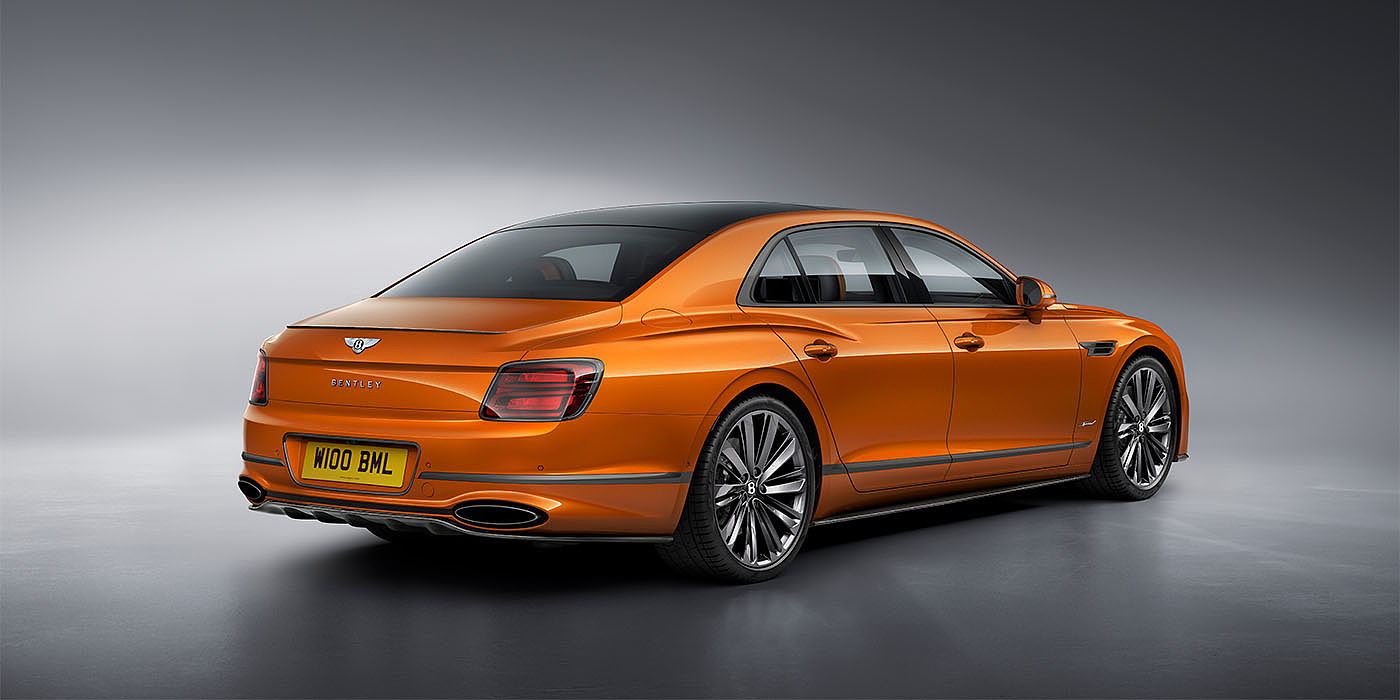 Bentley Marbella Bentley Flying Spur Speed in Orange Flame colour rear view, featuring Bentley insignia and enhanced exhaust muffler.