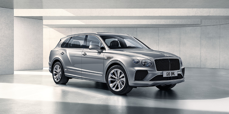 Bentley Marbella Bentley Bentayga Extended Wheelbase SUV front three quarter in Moonbeam paint with a grey background