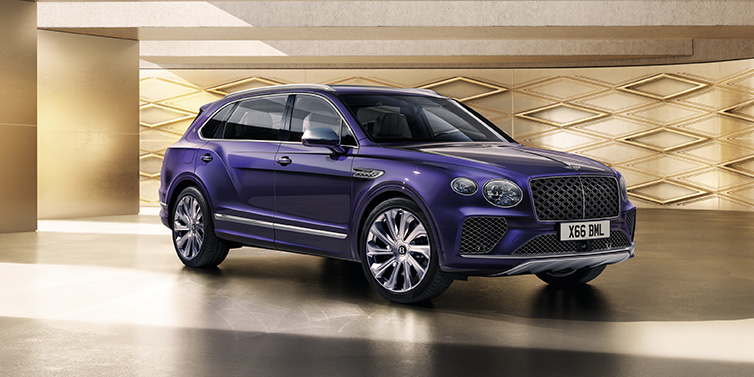 Bentley Marbella Bentley Bentayga Extended Wheelbase Mulliner SUV front three quarter in Tanzanite Purple paint with a gold patterned background