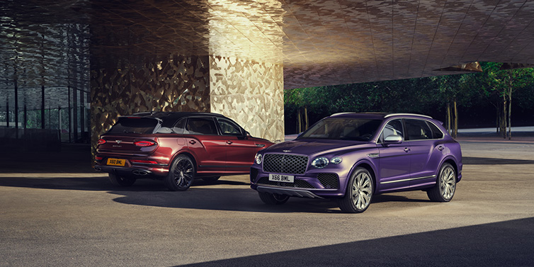 Bentley Marbella A duo of Bentley Bentayga Extended Wheelbase Mulliner SUVs parked in a city environment, with Tanzanite Purple and Cricket Ball red exterior paint